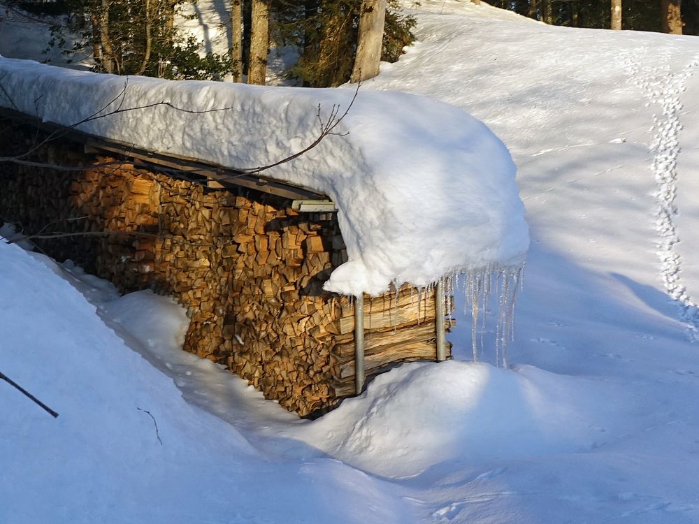 Schneerutsch auf einem Holzstapel