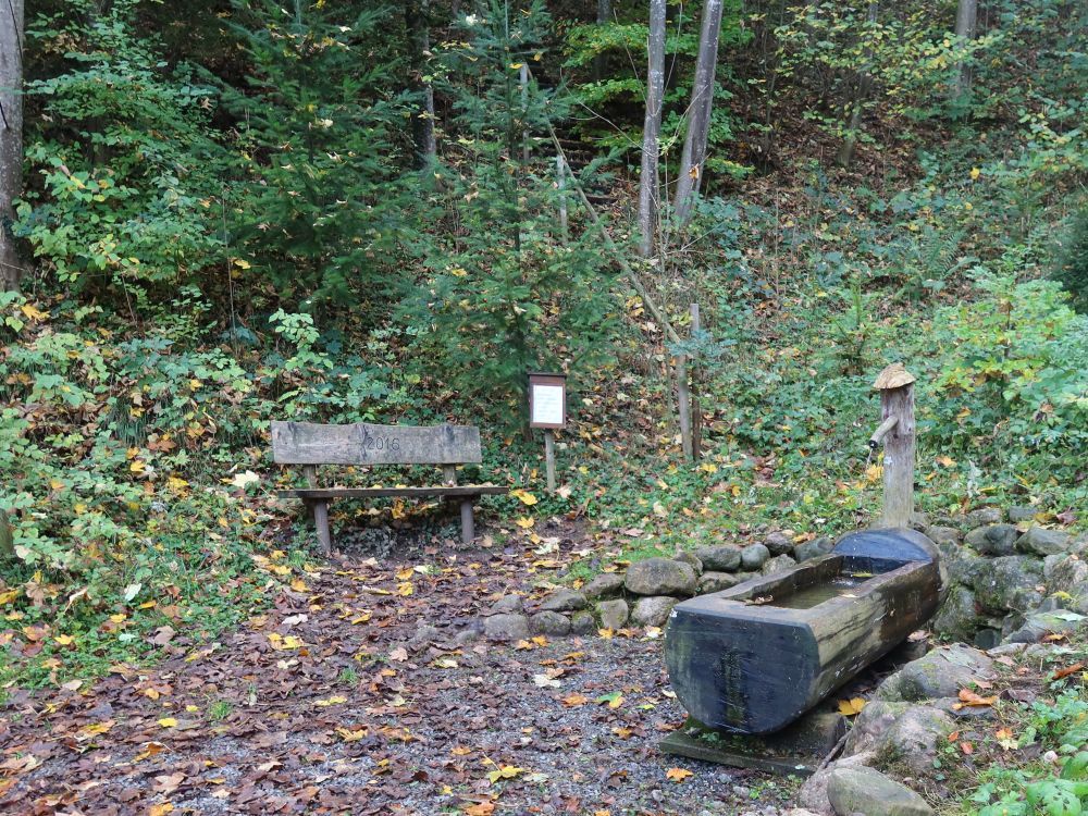 Sitzbank und Brunnen am Dorfbach